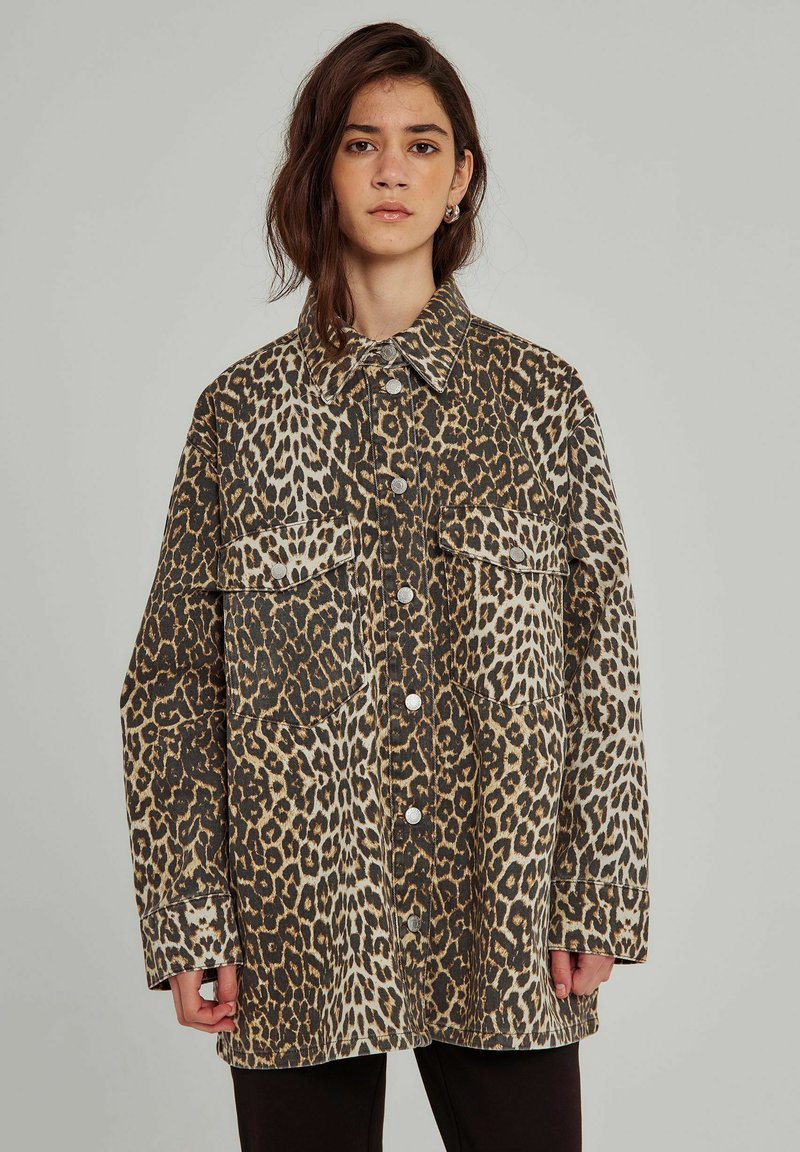 Leopardmönstrad jacka i brunt och krämigt, med krage, två bröstfickor, knäppning fram och lång ärm med avslappnad passform.