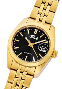 Reloj de cuarzo en tono dorado con esfera rectangular negra, marcadores de hora luminosos, display de fecha y pulsera de eslabones de metal dorado.