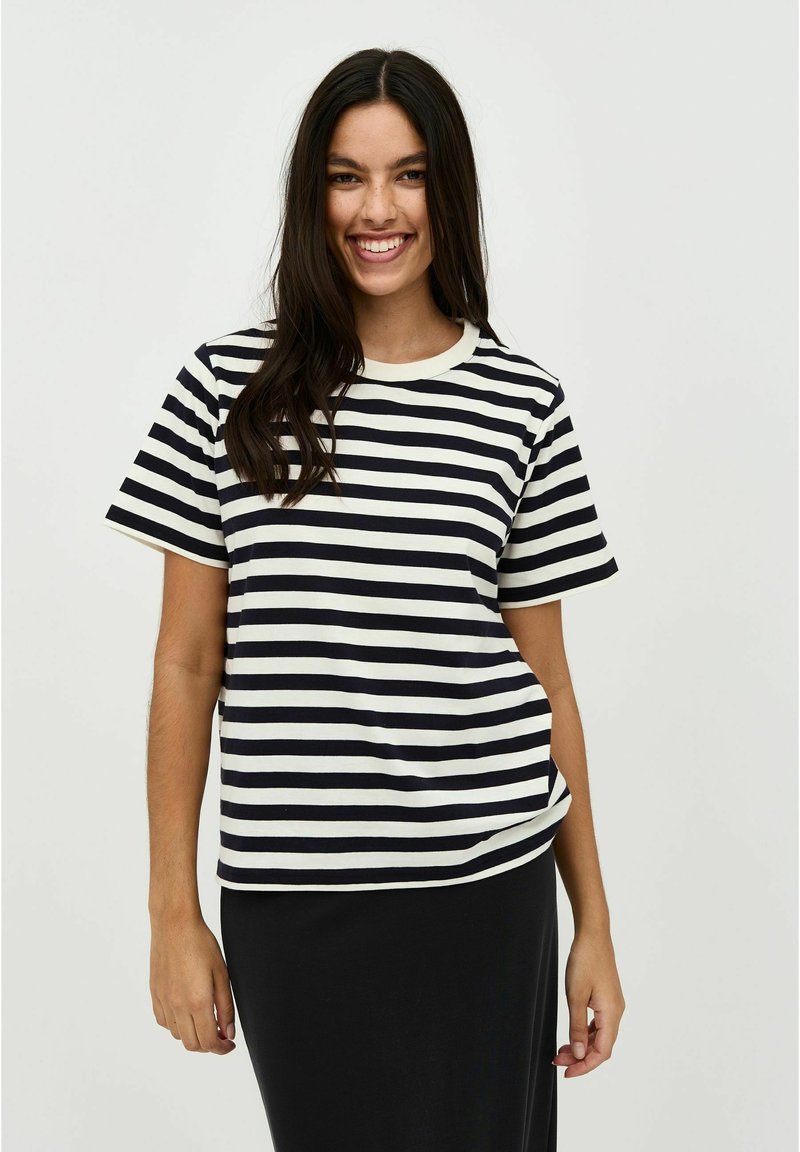 Striped short-sleeve t-shirt in navy and cream, featuring a round neckline and a relaxed fit, paired with a black skirt.