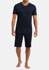 T-shirt à manches courtes bleu marine en V en tissu doux, associé à un short assorti, tous deux offrant un confort optimal et un design minimaliste.