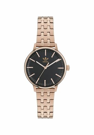 Montre-bracelet en métal or rose avec un cadran noir, des index et des aiguilles. Dispose d'un bracelet maillé et du logo adidas sur le cadran.