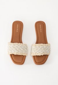 Sandales à glissière beiges avec une sangle en tissu texturé de couleur crème. Design à bout carré et semelle intérieure en cuir lisse avec des détails de couture.