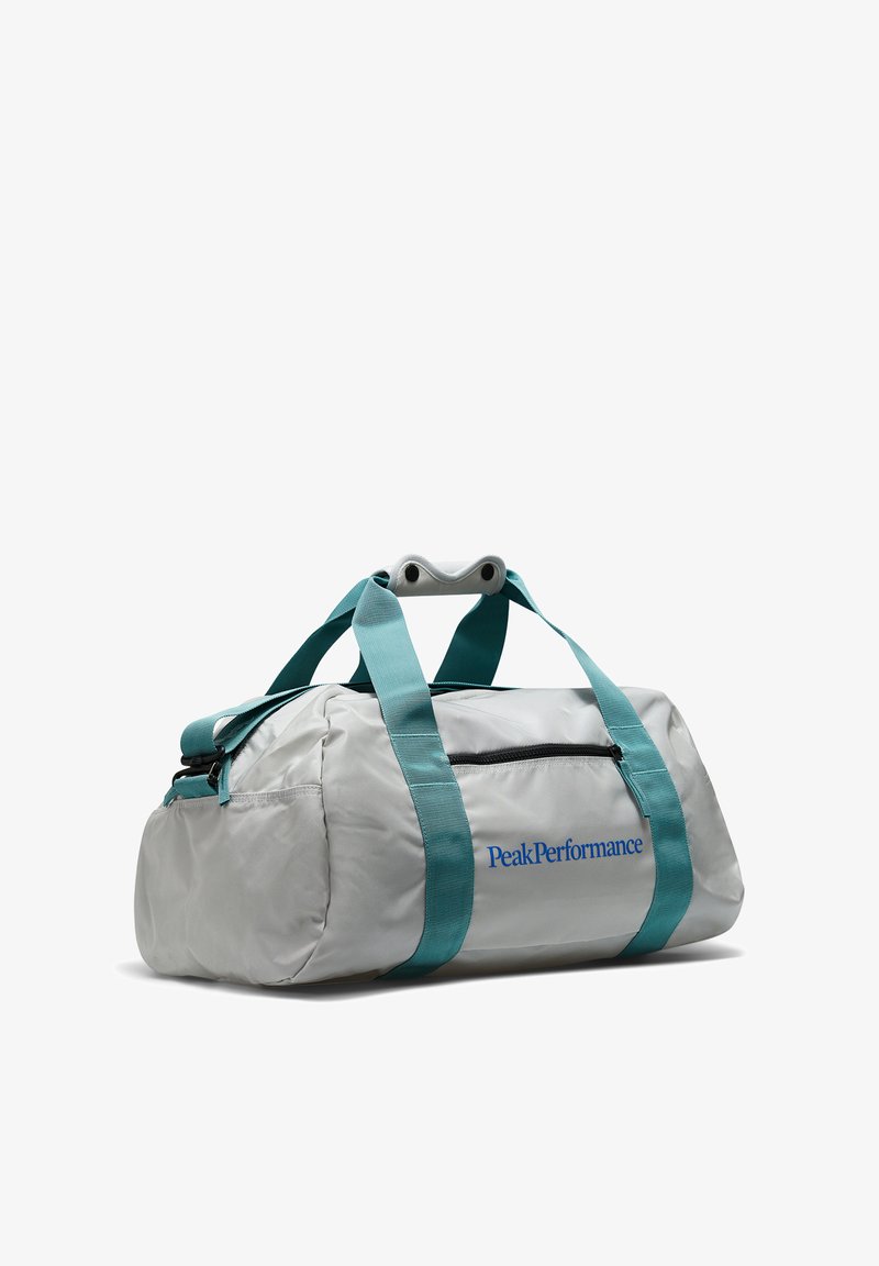 Mala de viagem cinza-claro com alças verde-água, bolso com fecho e logotipo "PeakPerformance". Feita de um tecido durável e liso. Forma arredondada.