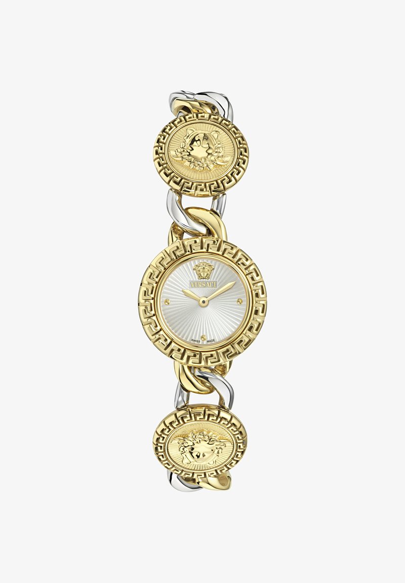 Kuldse ja hõbedatooniga käekell, millel on ümmargune kellaplaat triibulise hõbedase sihverplaadi, Kreeka võtmemustriga ja Medusa mündi aktsentidega käevõrul.