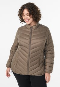 Padded jacket v zemitej hnedej farbe s stojatým golierom, šikmým švom a zipsovým uzáverom; má hladkú, ľahkú štruktúru.