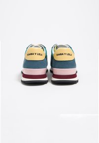 Niebiesko-turkusowe zamszowe sneakersy z żółtymi akcentami i czarnymi gumowymi podeszwami. Posiadają branding "BIMBA Y LOLA" na pięcie oraz kolorowe elementy wzornicze.
