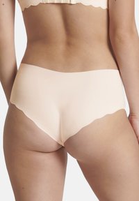 Perzikgekleurde naadloze bikini-stijl onderbroek met geschulpte randen. Glad textuur, middelhoge pasvorm en een minimalistisch dekking ontwerp.