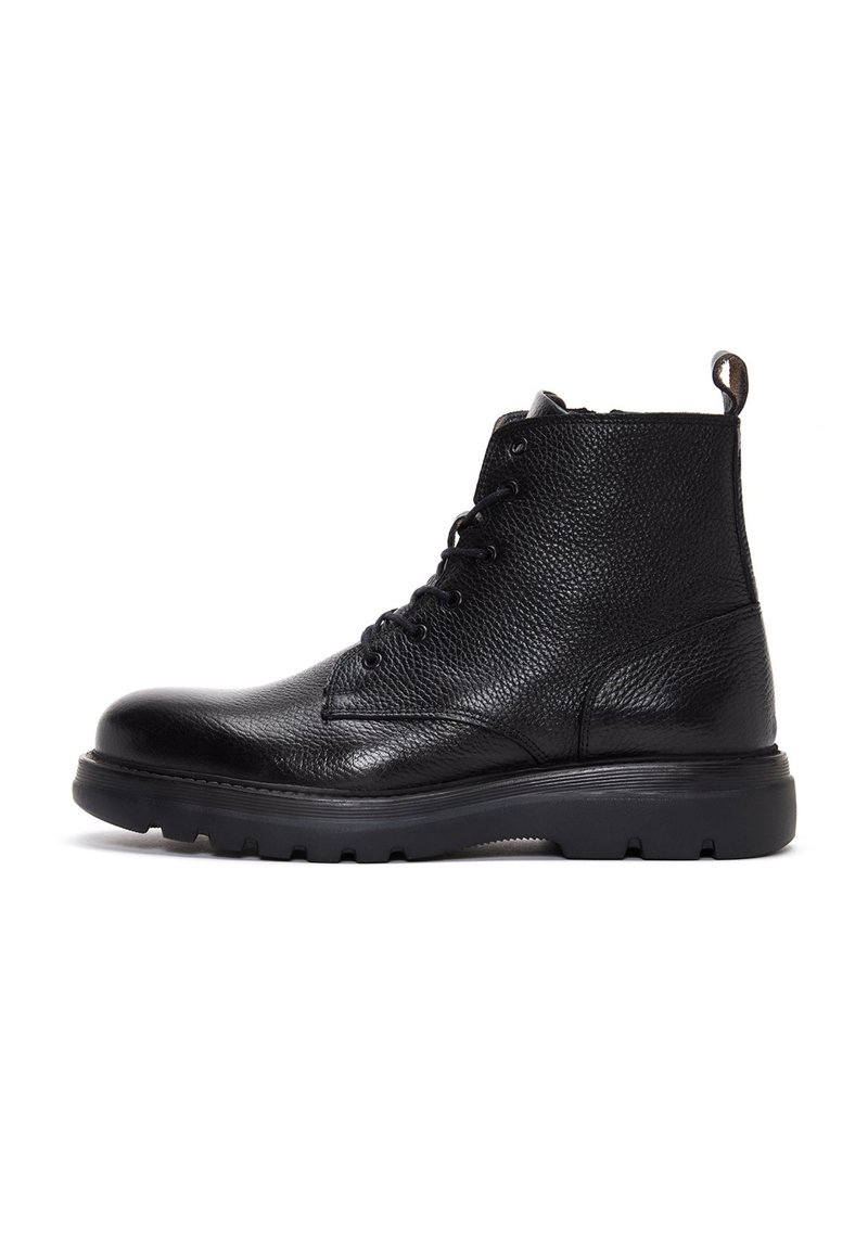 Bota de tobillo de cuero negra con acabado texturizado, puntera redonda, cierre de cordones en la parte delantera y suela de goma gruesa con tracción. Con tira en la parte posterior.