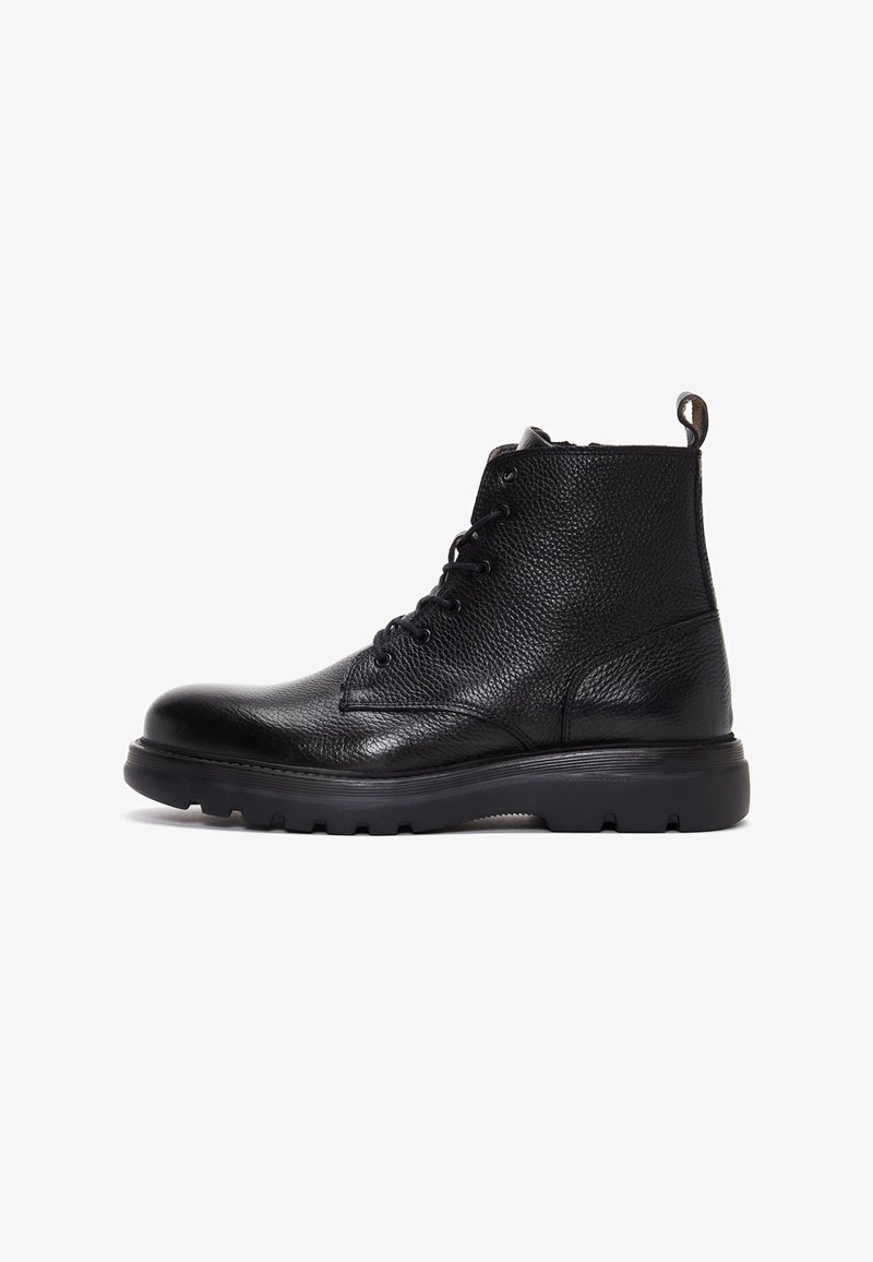 Bottine en cuir noir avec finition texturée, bout rond, laçage à l'avant et semelle en caoutchouc épaisse avec grip. Tirette à l'arrière.