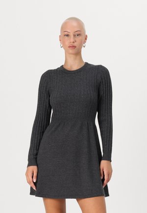 Robe en tricot grise avec texture côtelée, manches longues et corsage ajusté. La jupe évasée s'étend jusqu'à mi-cuisse.