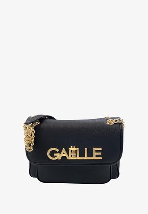 Borsa a tracolla in pelle nera con una catena dorata e un logo dorato sul fronte. Il design presenta una chiusura a patta e una forma strutturata.