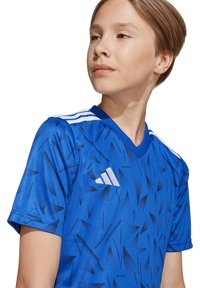 Blauwe sporttrui met korte mouwen, gekenmerkt door een gemêleerd patroon met donkeren blauwe accenten, een V-hals en witte schouderstrips.