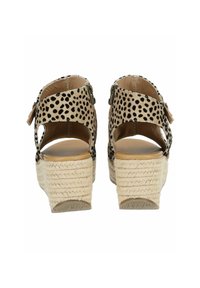 Černé sandály na klínu s puntíky, s pletenou juteovou patou, nastavitelným páskem, otevřenou zadní částí a hladkým béžovým podšívením.