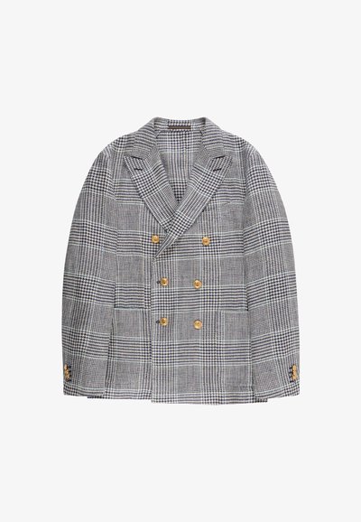 Blazer cruzado con patrón de cuadros blancos y negros y seis botones dorados, con solapas anchas y detalles de botones en los puños.