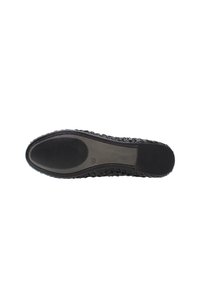 Suela de zapato de goma negra con una superficie texturada y con patrón. Presenta una superficie interna lisa y bordes estriados para mayor agarre.