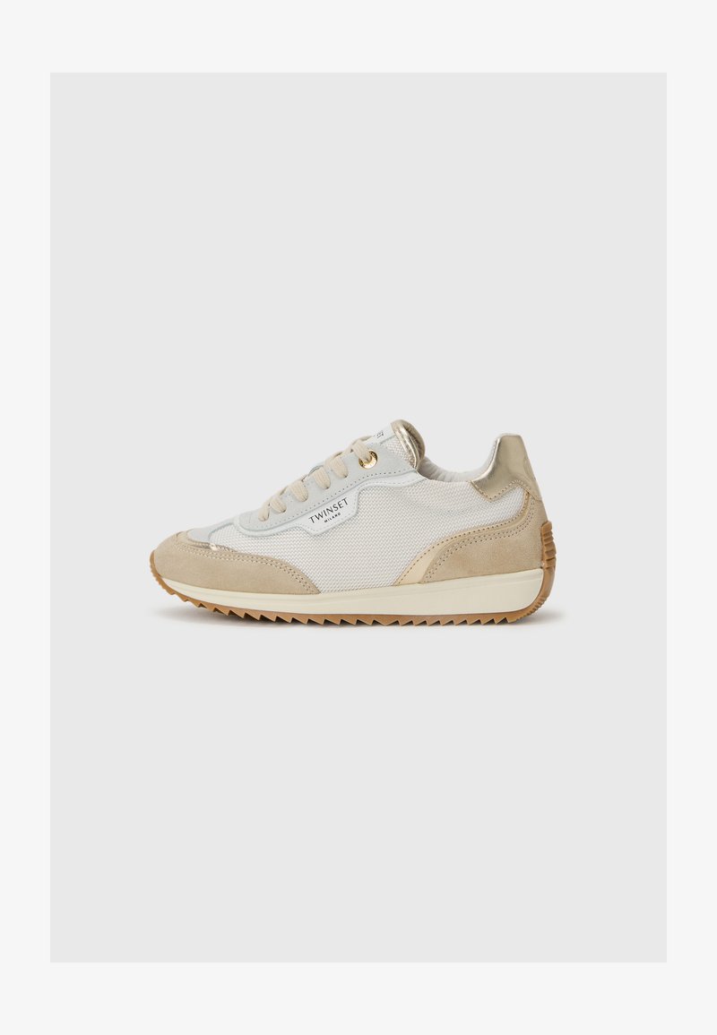 Baskets de sport beiges et blanches avec un corps en maille, des accents en daim, des détails en métal doré et une semelle en caoutchouc texturé.