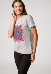 Grijze t-shirt met een levendige bloemenprint in roze en teal. Korte mouwen en een relaxed fit, gemaakt van een zachte katoenmix.