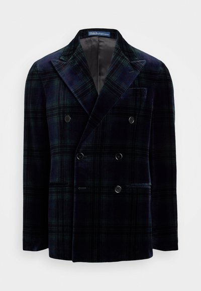 Veste à double boutonnage à carreaux en vert foncé et bleu marine, en velours. Présente de grands revers crantés et deux poches avant.
