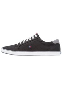 Sneakers neri in tela con lacci bianchi, dettagli grigi alla caviglia e suole in gomma bianca. Presentano un piccolo logo sul lato. Design a profilo basso.