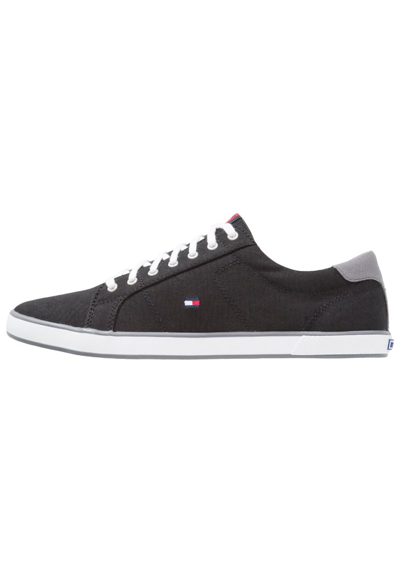 Sneakers neri in tela con lacci bianchi, dettagli grigi alla caviglia e suole in gomma bianca. Presentano un piccolo logo sul lato. Design a profilo basso.