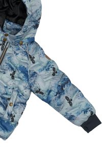 Polsterēta jaka ar zilzaļu un zaļu kalnu rakstu, melniem putnu motīviem, zelta rāvējslēdzēju un tumši ziliem ribotiem aprocēm.