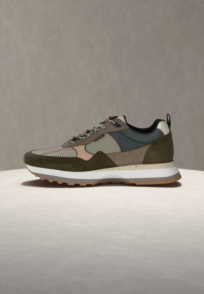 Low-top sneaker with mixed olive green, beige, and gray panels, white midsole, gum outsole, and lace-up closure on a neutral background.