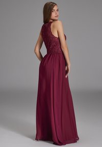 Bodenlanges burgunderfarbenes Kleid mit einem Spitzenoberteil, ärmellosem Design und fließendem Rock. Strukturiertem Stoff mit einer glatten Silhouette.