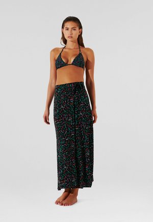 Conjunto de bikini con un top triangular negro estampado, acompañado de una larga falda negra con formas abstractas coloridas y cintura ajustable con lazo.