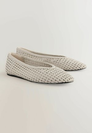 Ballerines en toile, à bout pointu, de couleur blanc cassé avec une finition texturée ; arborent une semelle noire basse et un design minimaliste.