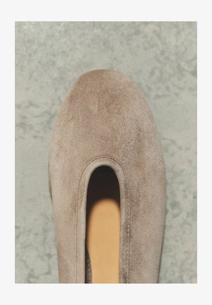 Üksik beežist seemisnahast libistatav king ümarate ninadega hallil tekstuuriga pinnal.