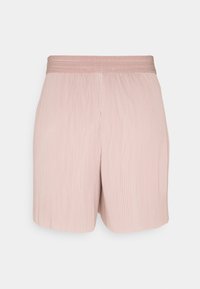 Shorts plissés rose clair avec une large ceinture texturée, vus de face sur un fond uni.