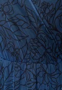 Blauer Netzstoff mit einem schwarzen Blumenmuster und strukturierter Oberfläche. Das Design umfasst sich überlappende Blätter und detailreiche Blütenblätter.