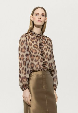 Bluse mit Leopardenmuster und Rüschenausschnitt sowie Rüschenfront, lange Ärmel. Kombiniert mit einem glatten, satinierten, hellbraunen Rock.