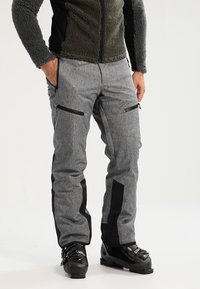 Pantalons de ski gris avec accents noirs, deux poches zippées et une coupe ajustée. Fabriqués en tissu durable, adaptés aux sports d'hiver.