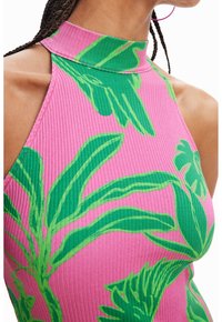 Ribbad halterneck-top i rosa med grönt tropiskt lövtryck. Nära bild visar textur och mönsterdetaljer.