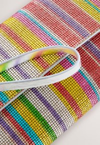 Clutch bag with multicolored rhinestones arranged in horizontal stripes and a looped handle resting on its surface.