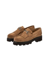 Par de mocasines de ante marrón con detalle de flecos y hebilla de metal plateada sobre suela de goma negra y gruesa.