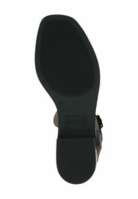 Fekete gumitalp, amely texturált felülettel rendelkezik, enyhe sarokkal és domború logóval. Az általános forma ergonomikus és egyedileg formázott.