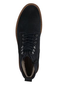 Botines de ante negros con suela de goma marrón. Presentan puntera redonda, diseño con cordones, cremallera lateral y forro texturizado.