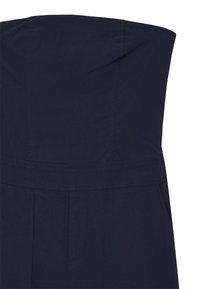 Tuta senza spalline di colore blu navy con busto strutturato, caratterizzata da una vita aderente e gambe affusolate. Tessuto liscio con cuciture minime e tasche.