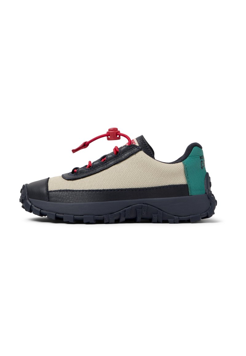 Zapatilla ligera con parte superior de tejido beige, acentos en azul marino, cordones rojos y suela de goma negra. Presenta una superficie texturizada y un diseño de punta redonda.