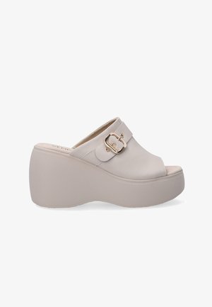 Beige platform mules made of smooth leather, featuring a wide strap with a gold-toned buckle, rounded open toe, and textured sole.