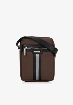 Hnědá nylonová crossbody taška s černými koženými akcenty, stříbrným zipem a předním pruhovaným designem. Nastavitelný popruh pro přizpůsobení.