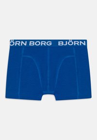 Plave pamučne bokserice s širokim elastičnim pojasom na kojem se nalazi bijelo natpis "BJÖRN BORG", oblikovane s prednjim džepom i ravnim šavovima.