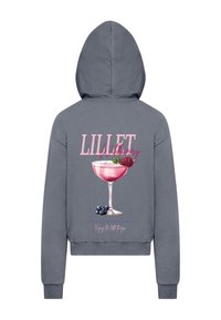 Szürke kapucnis pulóver, amelyen egy koktélpohár pink grafikája látható bogyós gyümölcsökkel. A szöveg így olvasható: "LILLET Wildberry" játékos betűtípussal.