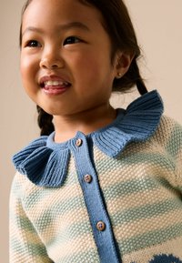 Gebreid vest met pastelkleurige strepen in crème en lichtblauw, voorzien van een gerimpelde blauwe kraag en houten knopen. Zachte textuur en speels ontwerp.