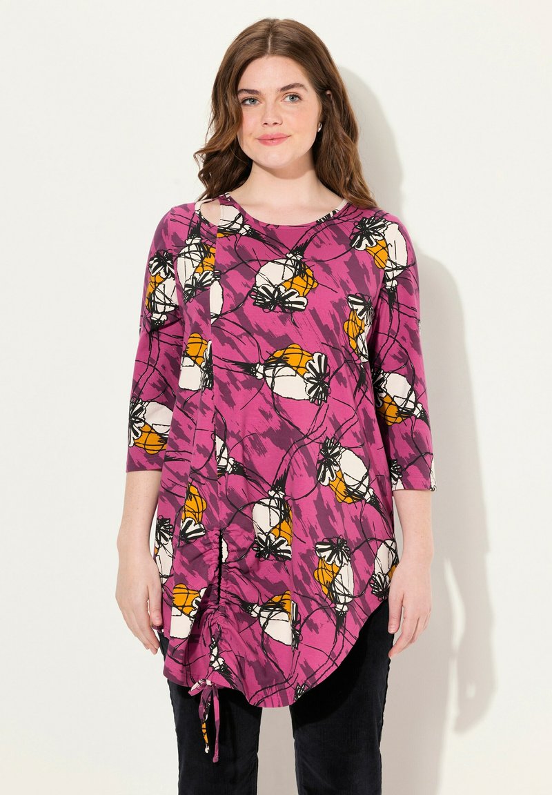 Túnica de manga larga en color rosa con estampado floral en blanco y naranja. Cuello redondo, detalle fruncido en los laterales y dobladillo curvado. Confeccionada en tela ligera.