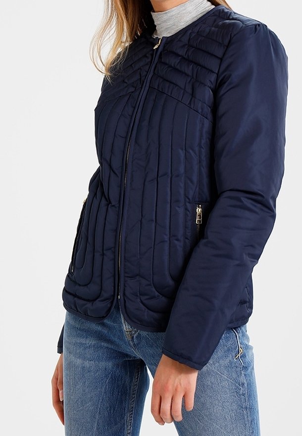 Navy gewatteerde jas met een ritssluiting aan de voorkant, voorzien van een ronde halslijn, horizontale naaien, zijzakken met rits en een gladde textuur.
