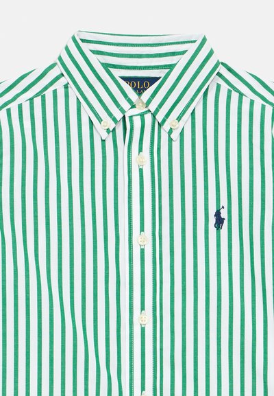 Πράσινο και λευκό κατακόρυφα ριγέ πουκάμισο με κουμπιά, γιακά με κουμπί κα�ι μικρό ναυτικό μπλε λογότυπο παίκτη πόλο στο στήθος.