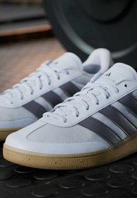 Lichtblauwe sportschoenen van gestructureerd materiaal met marineblauwe strepen, voorzien van een rubberen gum zool en een klassiek veterontwerp.